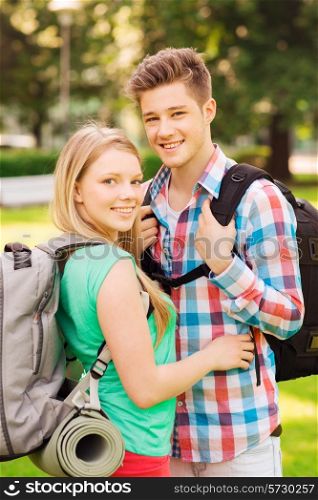travel, vacation, tourism and friendship concept - smiling couple with backpacks in nature