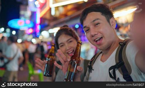 Traveler Asian blogger couple travel in Bangkok, Thailand, sweet couple using mobile phone make vlog and live in social media while hangout at The Khao San Road. Couple travel in Thailand concept.