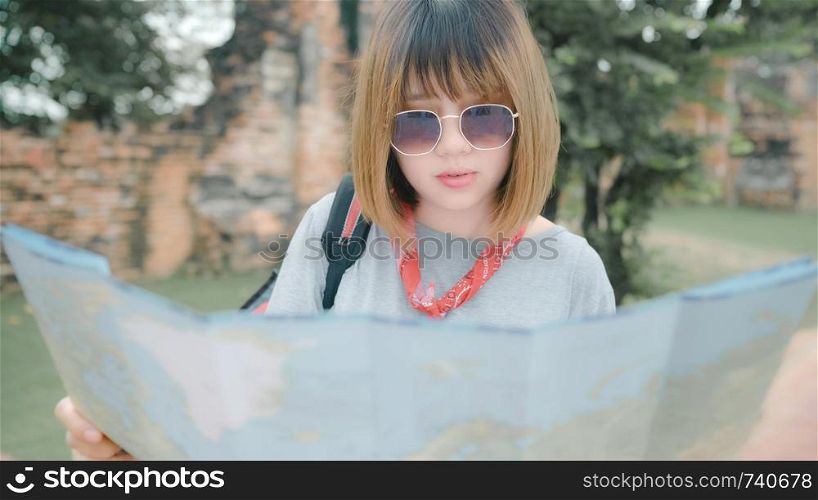 Traveler Asian woman direction and looking on location map while spending holiday trip at Ayutthaya, Thailand, backpacker female enjoy journey in traditional city. Lifestyle women travel concept.