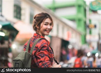Traveler backpacker asian woman travel in Khao San road at Bangkok, Thailand. Happy young female spending holiday trip at amazing landmark and enjoy her journey in traditional city.
