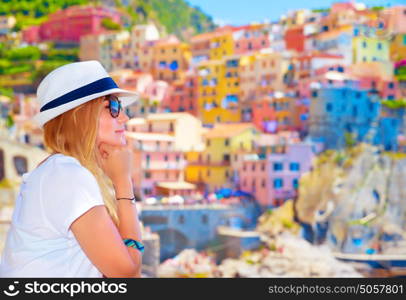 Traveler girl enjoying colorful cityscape, spending summer vacation in Europe, Italy, Cinque Terre, beautiful painted buildings