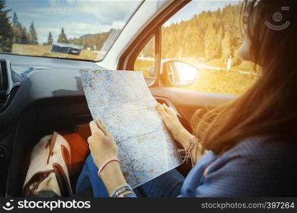 traveler girl look at the map sitting in car, Italy