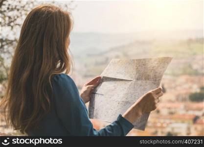traveler girl looks at the map of walking in Certaldo. Tuscany, Italy