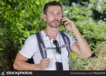 traveler holding mobile phone in nature