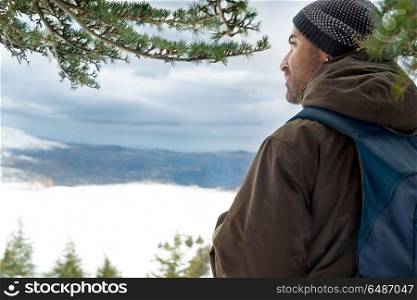 Traveler in the snowy mountains, back side of a man standing and enjoying beautiful peaceful winter view, Eco tourism, active winter traveling . Traveler in the snowy mountains
