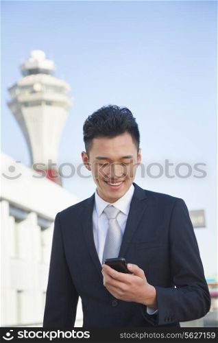Traveler looking at cell phone message at airport