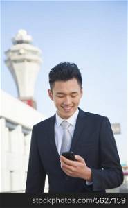Traveler looking at cell phone message at airport