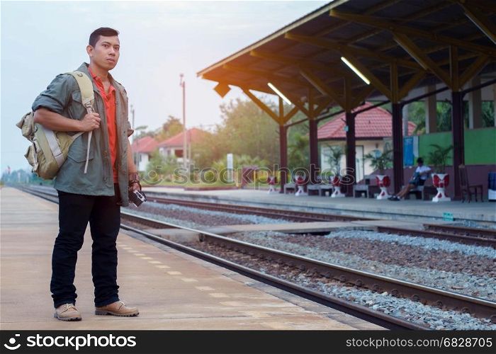 Traveler man waiting with backpack in train station. Travel concept.