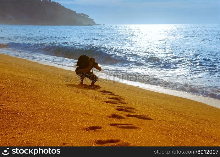 Traveler photographer take pictures on the sandy beach at popular holiday resort Lloret de Mar on Costa Brava in the morning , Catalunya, Spain