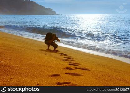 Traveler photographer take pictures on the sandy beach at popular holiday resort Lloret de Mar on Costa Brava in the morning , Catalunya, Spain