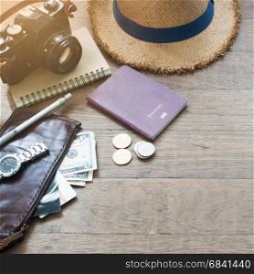 Traveler's accessories, Essential vacation items of young man with passport, camera and purse on wood background with copy space
