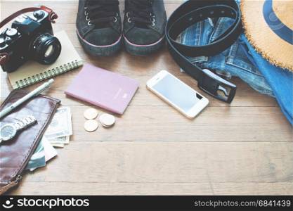 Traveler's accessories, Essential vacation items of young man with passport, camera, mobile device and purse on wood background with copy space