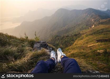 Traveler sitting and looking at view of nature at top of mountain. Traveler sitting and looking at view of nature