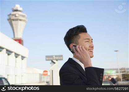 Traveler talking on cellphone outside at airport
