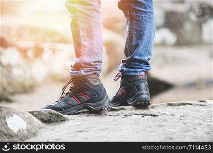 traveler walking in forest in the rock mountains / Man hiker legs and feet in shoes