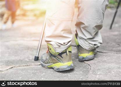 traveler walking on the rock in forest in the mountains / Man hiker legs and feet in shoes
