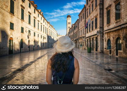 Traveler walks on the historic street of Stradun (Placa) in old town of Dubrovnik in Croatia - Prominent travel destination of Croatia. Dubrovnik old town was listed as UNESCO World Heritage in 1979.