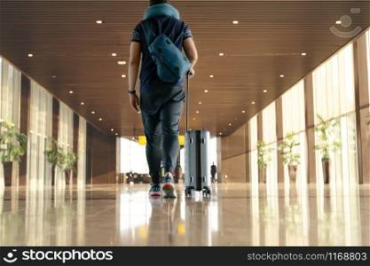 traveler with suitcase walking with carrying luggage and passenger for tour in the airport terminal for air traveling