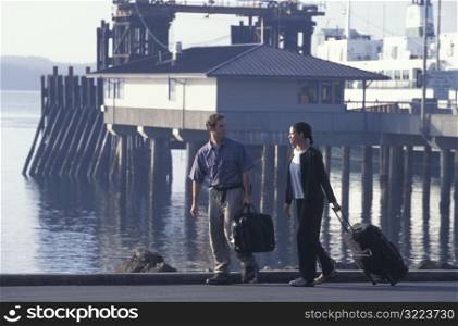 Travelers Walking With Suitcases Along The Pier