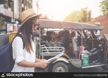 Travelers young woman with backpack looking hold a map at the capital, Travel ideas.