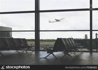 Traveling concept - empty interior of the airport lounge on the background of flying aircraft (vintage effect)