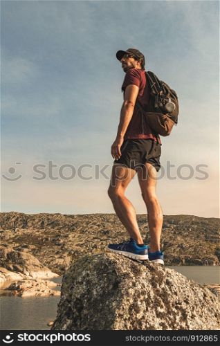 Traveling Man tourist with backpack hiking in mountains landscape active healthy lifestyle adventure vacations on rocky mountain.