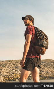 Traveling Man tourist with backpack hiking in mountains landscape active healthy lifestyle adventure vacations on rocky mountain.