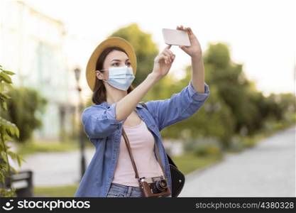 traveller with face mask hat taking pictures