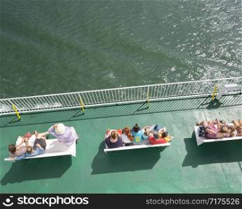 travellers sitting on ferry bench seen from above