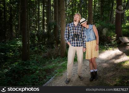 Travelling couple walking together in summer forest