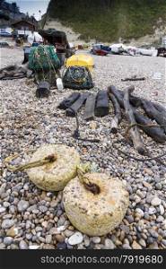 Trawler fishing nets and equipment set out on the stony beach at Beer, Devon, England, United Kingdom