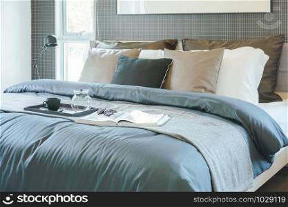 Tray of tea set, book and sunglasses setting on bed in modern classic style interior bedroom