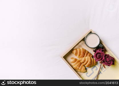 tray with croissants roses bed