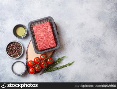 Tray with raw minced homemade beef meat with spices and herbs. Top view and space for text. On kitchen table background.