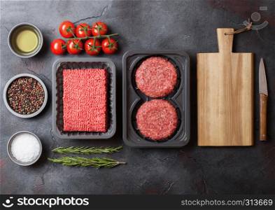 Tray with raw minced homemade beef meat with spices and herbs. Top view. On kitchen table background.