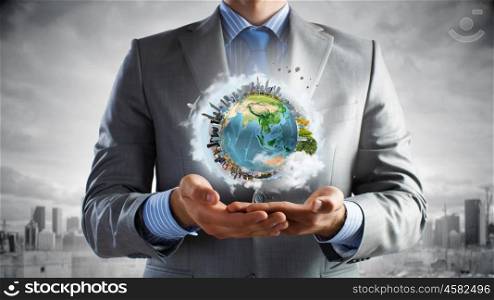 Treat our planet with love. Young businessman holding Earth planet in hand. Elements of this image are furnished by NASA
