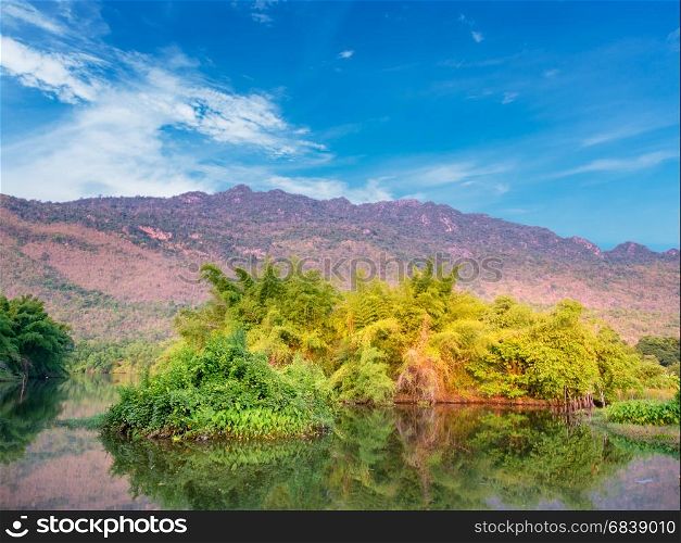 Tree in river with mountain and blue sky in morning,Thailand