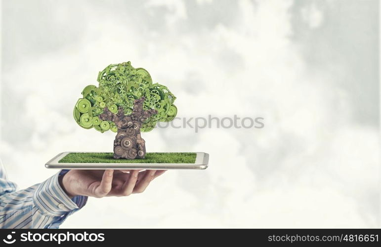 Tree of gears. Environmental concept with hand hold green tree of industrial gear