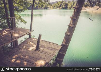Treehouse wooden platform at a beautiful blue lake
