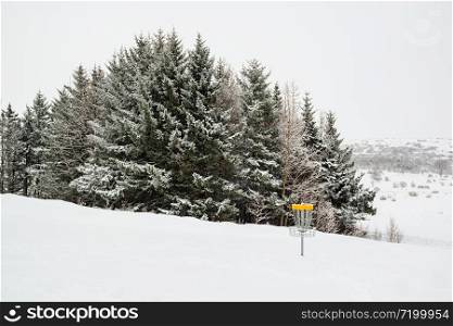Trees under the snow and disk golf in a winter day in Gardabaer, Iceland. Trees under the snow and disk golf, Iceland