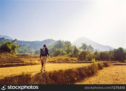 Trekking and camping adventure concept from asian couple hiking with backpack while walk to the mountain in summer season.