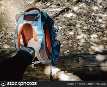 Trekking and camping adventure concept from hand of traveler started carrying a backpack for hiking. While walk travel nature in forest.