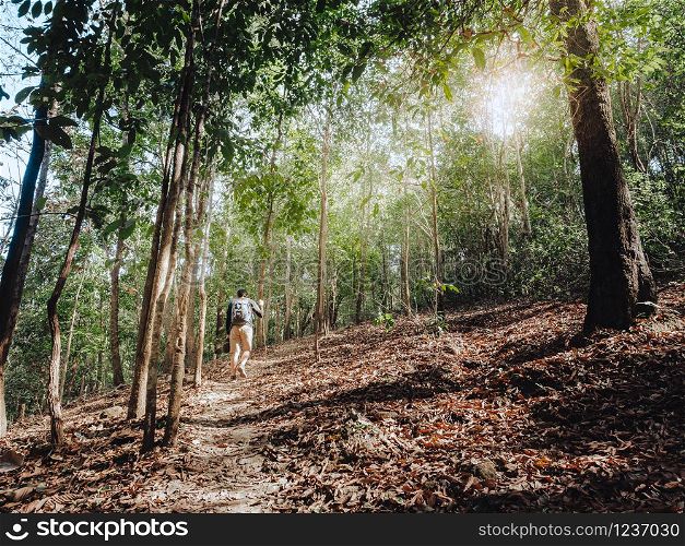 Trekking and camping adventure concept from Man traveling with backpack hiking in tropical rain forest.