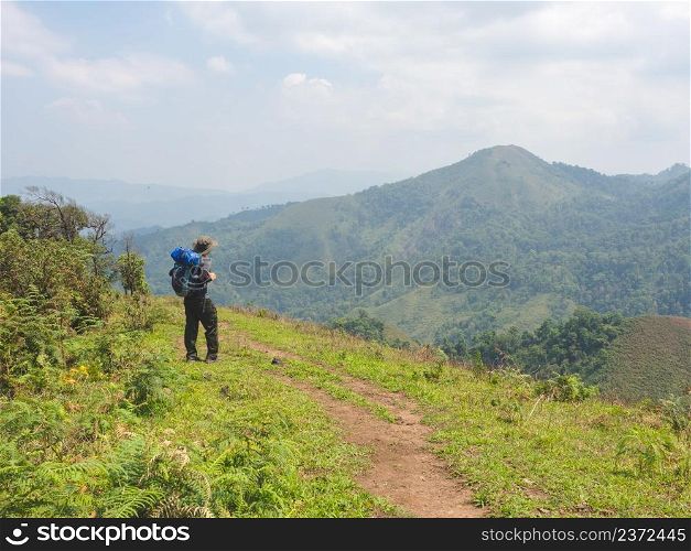 Trekking solo backpack on mountain trail in tropical forest at Tak Province, Thailand.