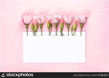 Trendy banner for Valentines Day, International Womens Day or mothers day. Party or wedding invitation. Eustoma flower arrangement with flowers and blank card, on pink background. Eustoma flower arrangement with flowers and blank card, on pink background
