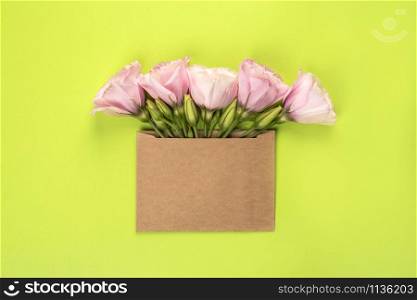 Trendy banner for Valentines Day, International Womens Day or mothers day. Party or wedding invitation. Eustoma flower arrangement with flowers and blank card, on green background. Eustoma flower arrangement with flowers and blank card, on green background