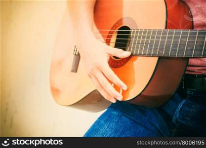 Trendy guy with guitar outdoor. Performance and show on fresh air. Part body of young fashionable man playing classic guitar outdoor. Summer time.