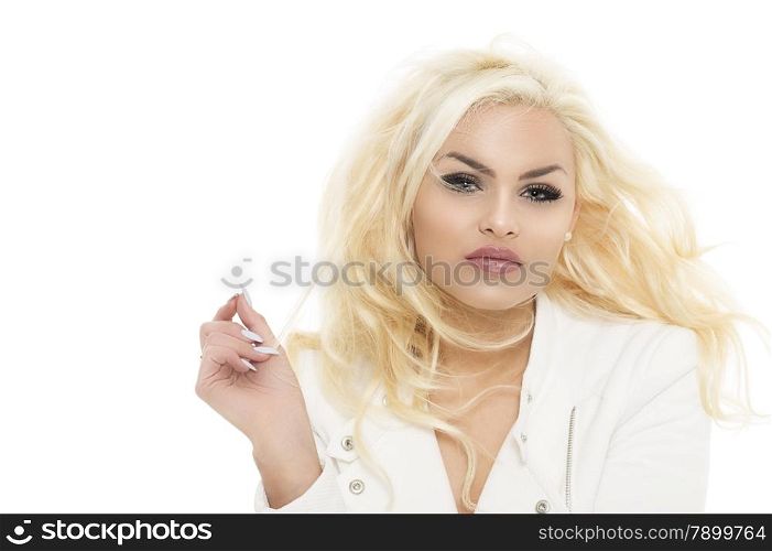 Trendy stylish attractive young woman with her wavy blond hair blowing to the side in the wind looking at the camera with a thoughtful expression, over white