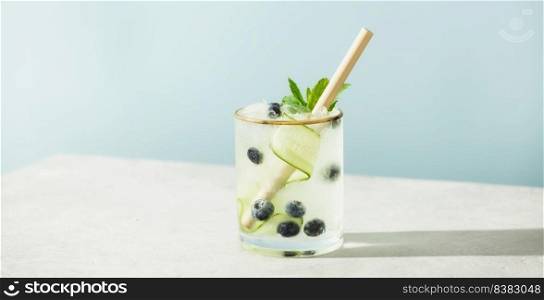 Trendy summer drinks with cucumber, mint and blueberry on blue sky background. Vacation concept. Trendy summer drinks with cucumber, mint and blueberry on blue sky background