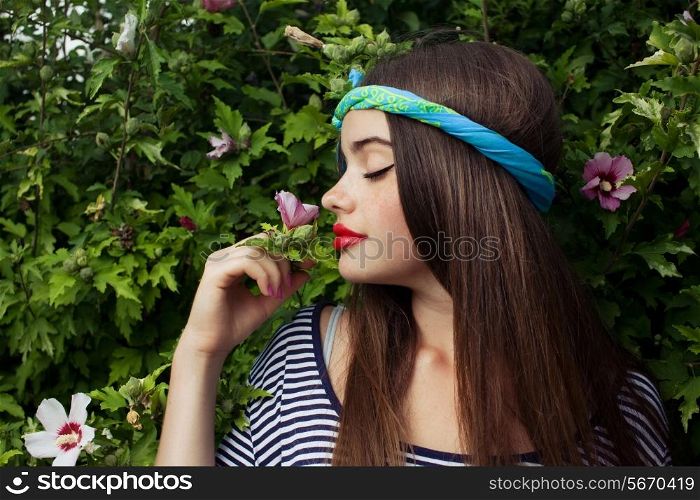 trendy teenager model with big lips smelling flowers